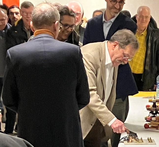 Alain Aspect allume des bougies en activant un sectionneur issu des collections du Musée ( récupéré en 2022 dans la menuiserie GONIN à Francheville le bas, il commandait un moteur Tissot-Dupont, fabricant lyonnais situé Boulevard Thiers à Lyon)
